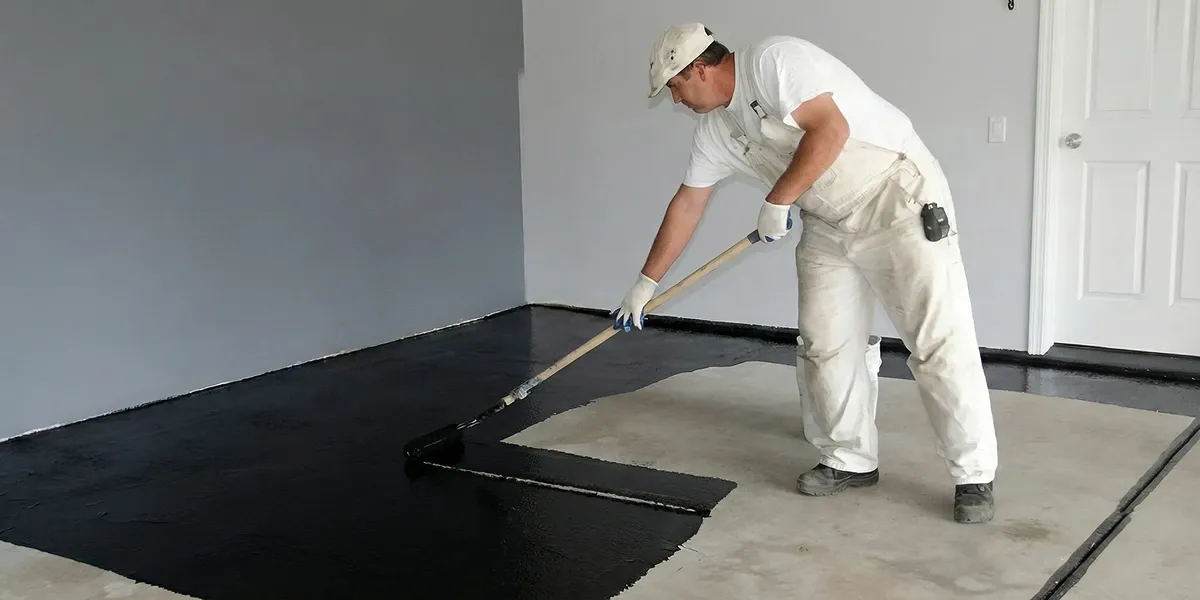 basement waterproofing professional applying waterproof coating to protect a basement floor in Naperville, IL