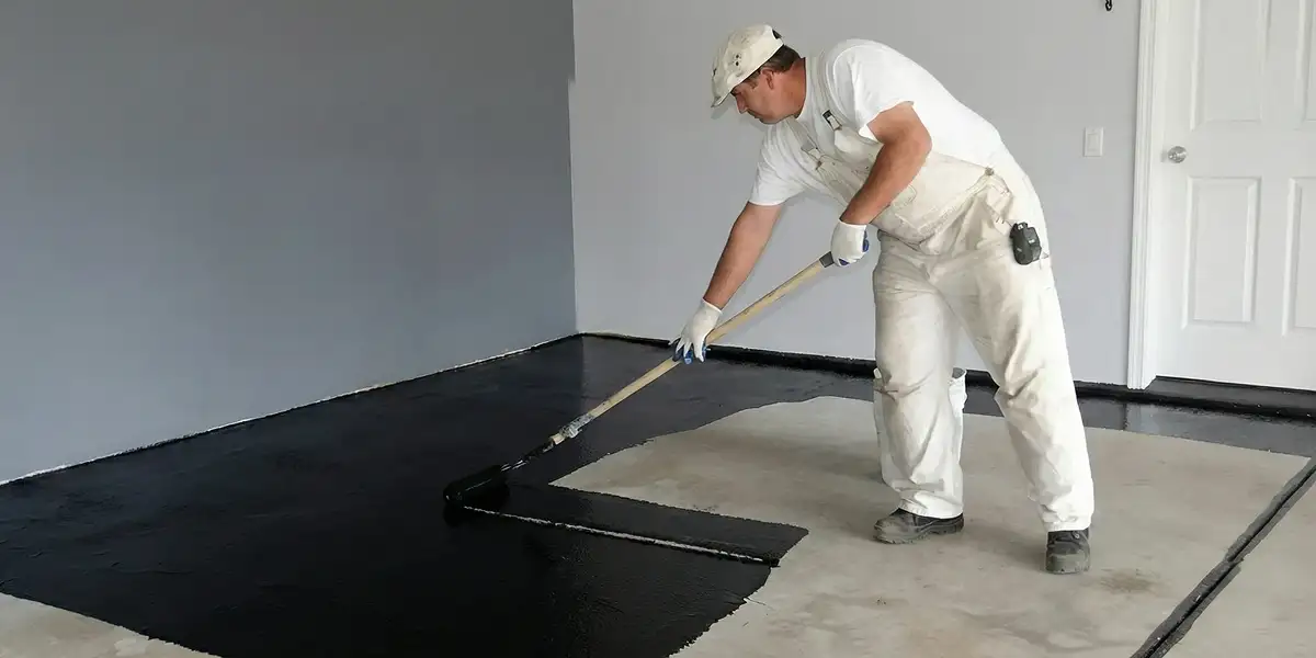 basement waterproofing professional applying waterproof coating to protect a basement floor in Naperville, IL